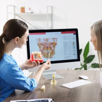 Une dentiste parle des implants dentaires avec une patiente plus âgée lors d'une consultation